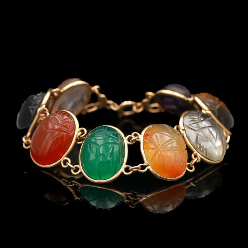 a gold bracelet with four different colored stones