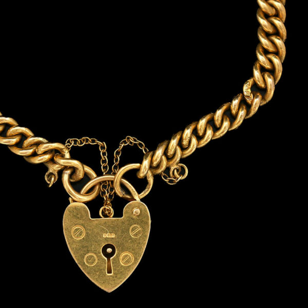 a gold necklace with a heart shaped lock on it