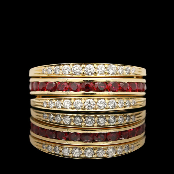 a stack of gold rings with red and white stones