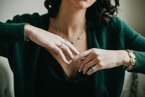 a woman in a green cardigan is holding her hands together