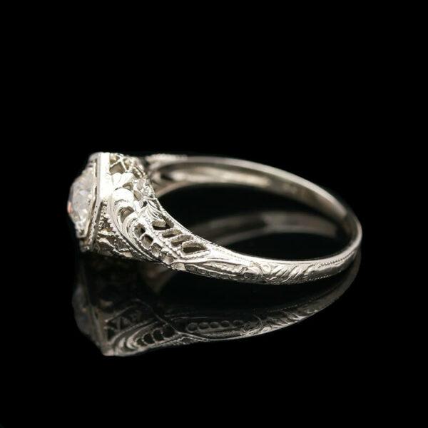 an antique style diamond ring on a black background