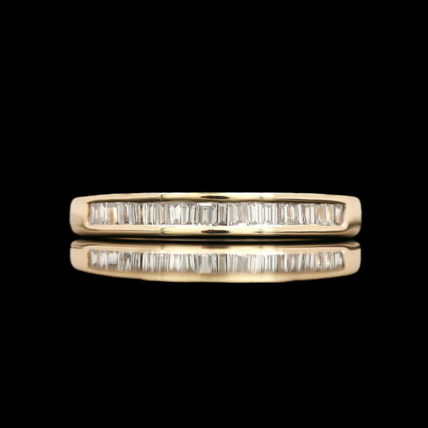 a gold wedding band with baguetts of diamonds