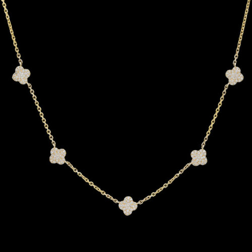 a gold necklace with four clovers on it