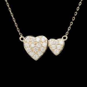 two heart shaped diamond pendants on a gold chain