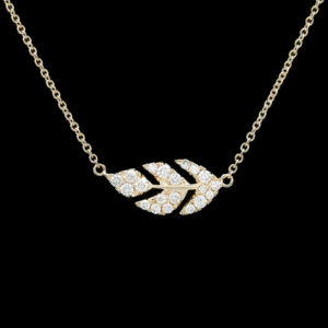 a gold necklace with two leaves on it