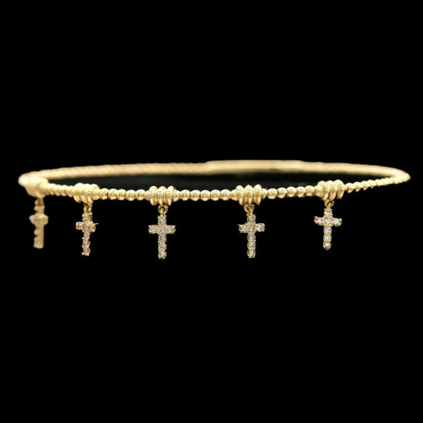 a gold bracelet with three crosses on it