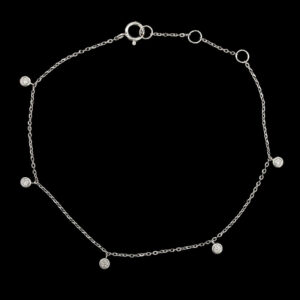 a silver ankle bracelet with five circles on it