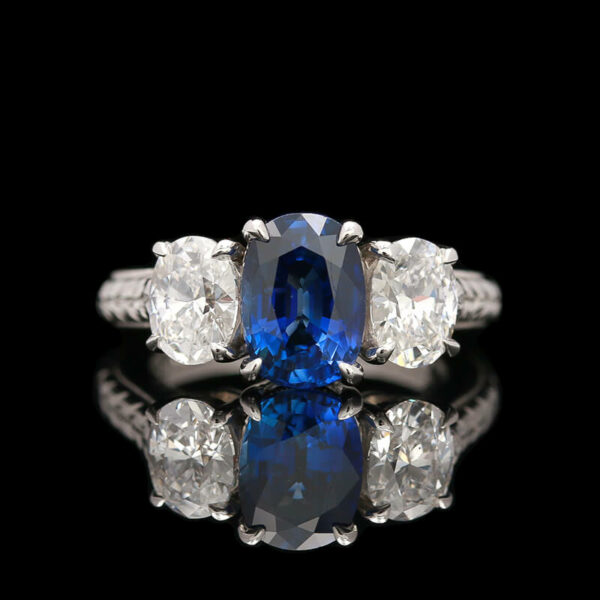 a blue and white ring with three diamonds