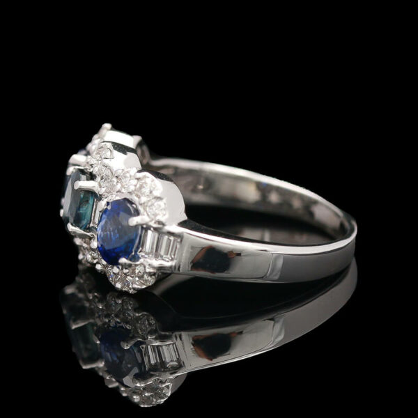 a diamond and blue sapphire ring on a reflective surface