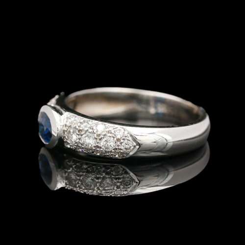 a white gold ring with diamonds and blue sapphire