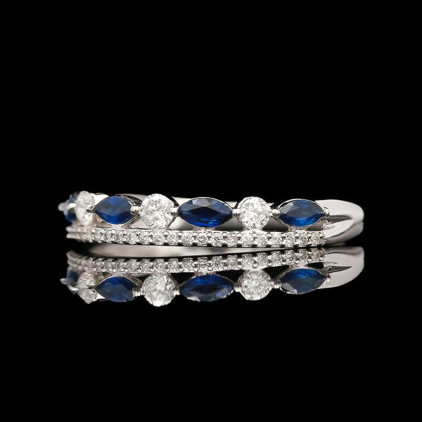 a diamond and blue sapphire ring on a black background