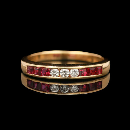 a gold ring with red and white stones