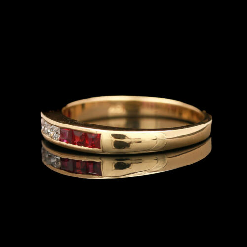 a yellow gold ring with red and white stones