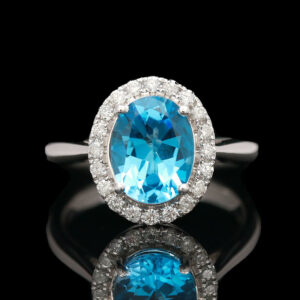 an oval blue topaz ring with diamonds around it
