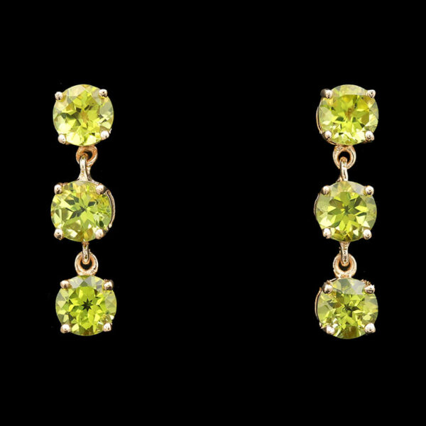 a pair of yellow earrings with green stones