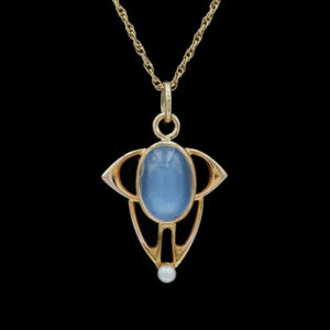 a gold necklace with a blue stone in the center
