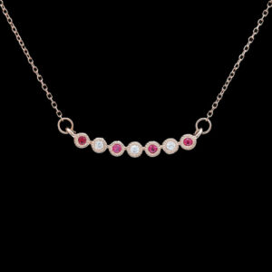 a pink and white diamond necklace on a black background