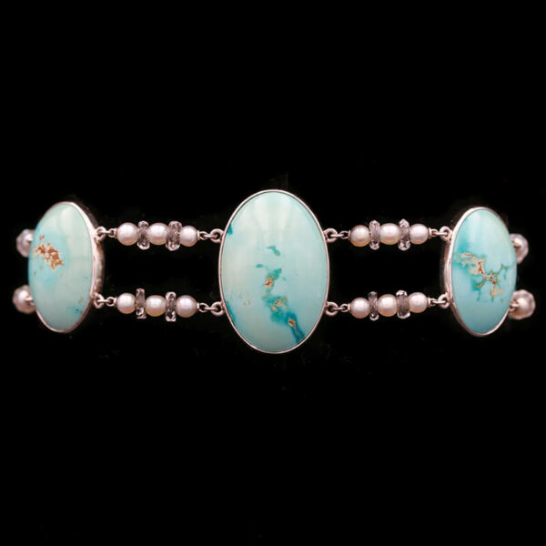 a silver bracelet with turquoise stones and pearls