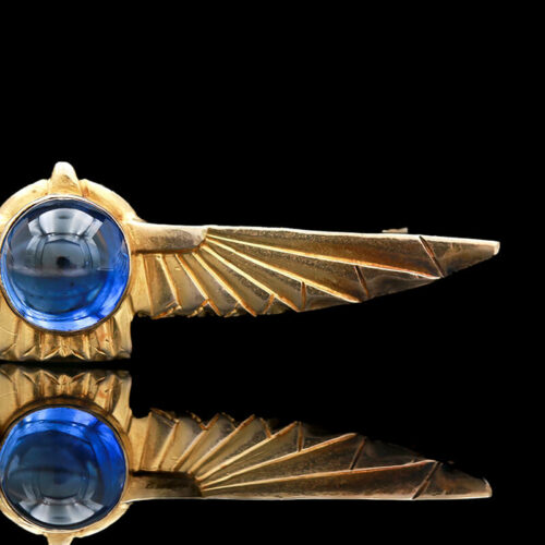 an antique brooch with blue glass in the center