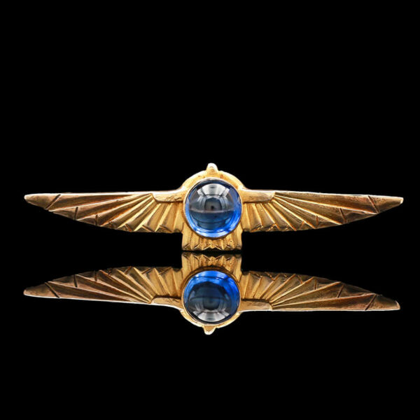 a gold brooch with two blue stones on it