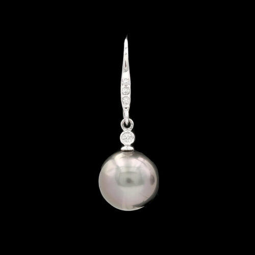 a pearl and diamond pendant on a black background