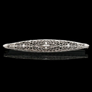 a silver brooch with intricate designs on it
