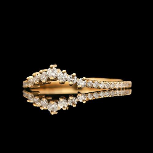 a gold ring with diamonds on a black background