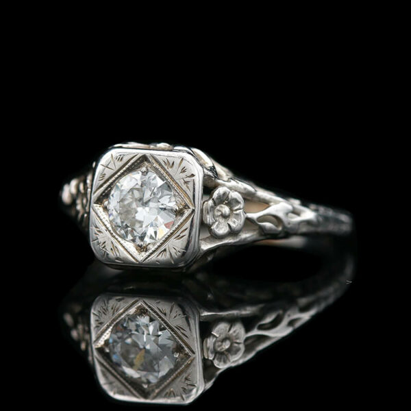 an antique style diamond ring on a black background