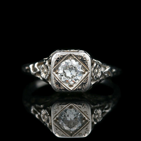 an antique style diamond ring with filigrees