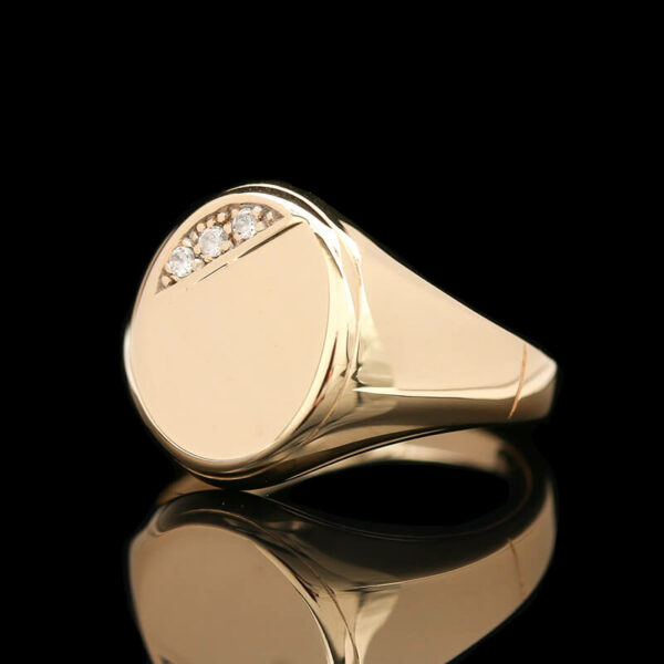a gold signet ring with three diamonds