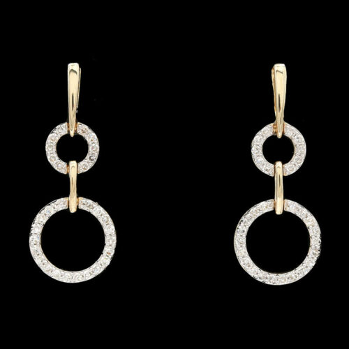 a pair of earrings with white diamonds on black background