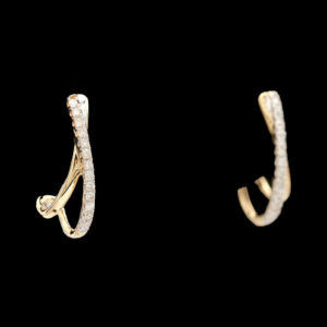 two gold and diamond earrings on a black background