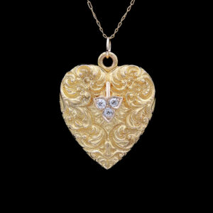 a gold heart shaped locke with two diamonds