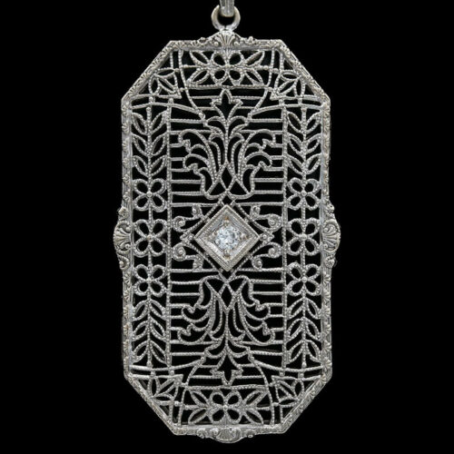 an intricately designed pendant with a diamond in the center
