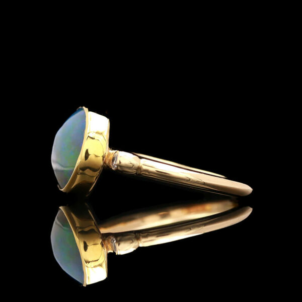a pair of gold sunglasses sitting on top of a black surface