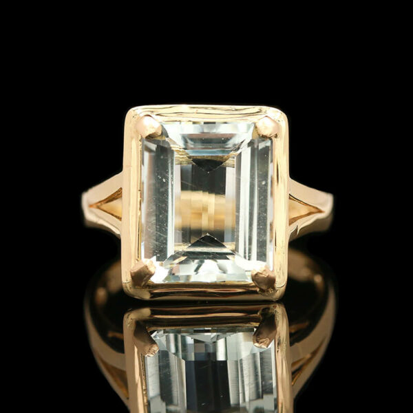 a gold ring with an emerald cut diamond