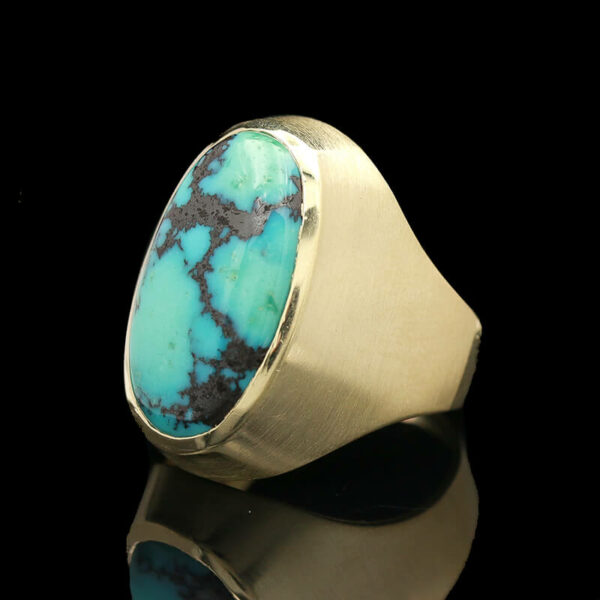 a gold ring with a turquoise stone in it