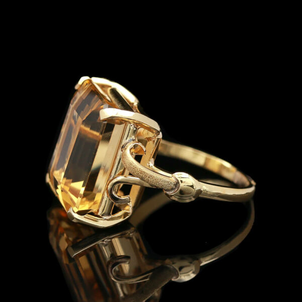 a fancy yellow gold ring with an oval cut citrine