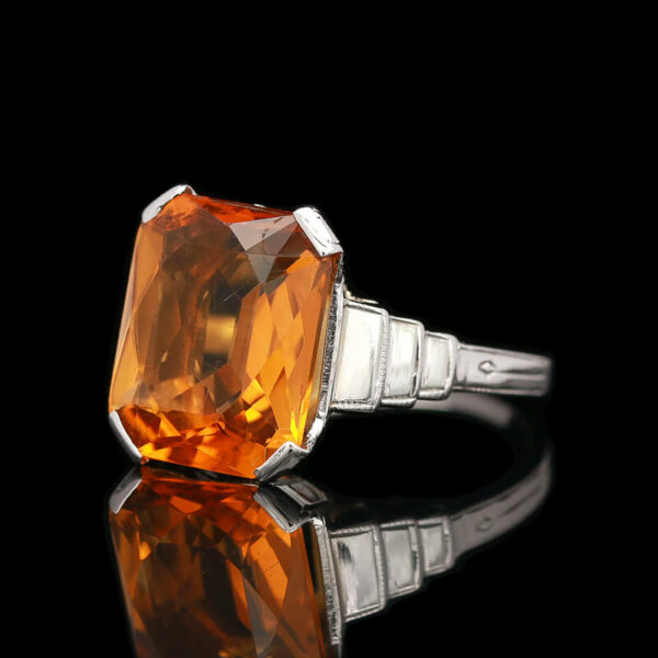 a fancy ring with an orange stone in the center