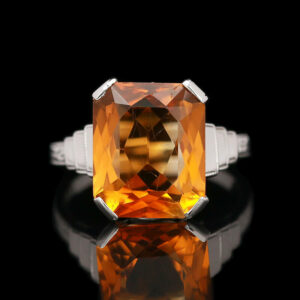 an orange and white diamond ring on a black background