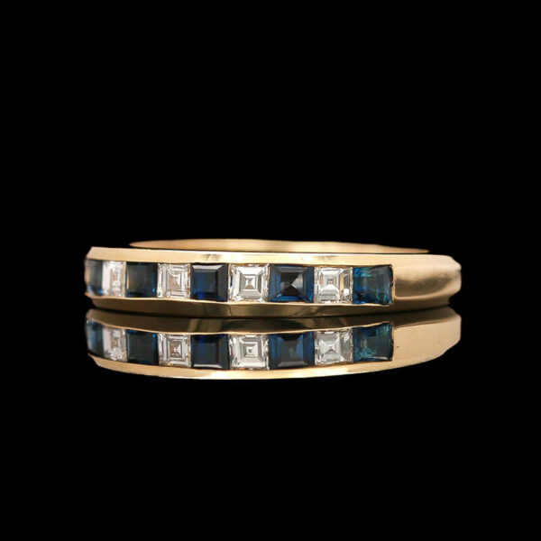a yellow gold ring with blue and white diamonds