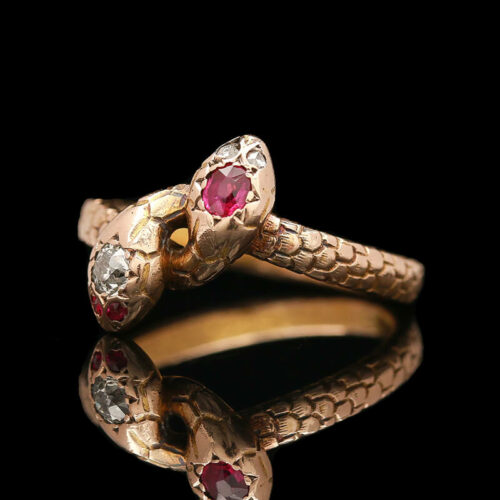a gold snake ring with two red and white stones