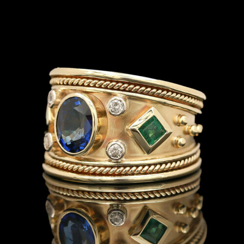 a stack of gold rings with blue and green stones