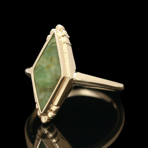 a gold ring with a green stone in it