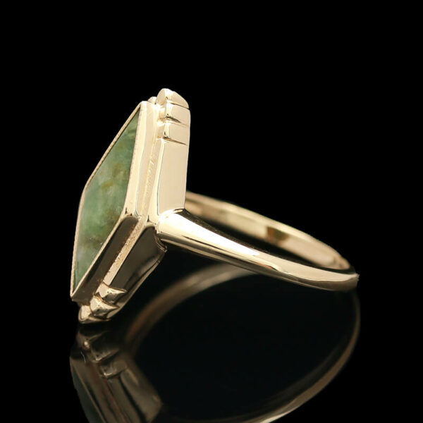 a gold ring with a green stone in it