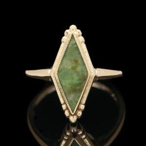a ring with a green stone in the middle