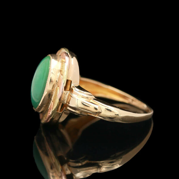 a gold ring with a green stone on it