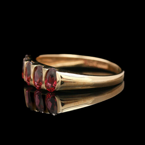 a gold ring with three red stones on it