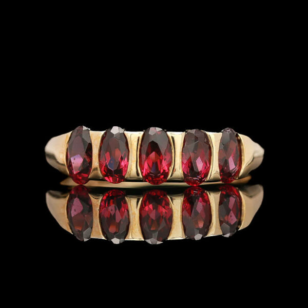 a gold ring with red stones on it