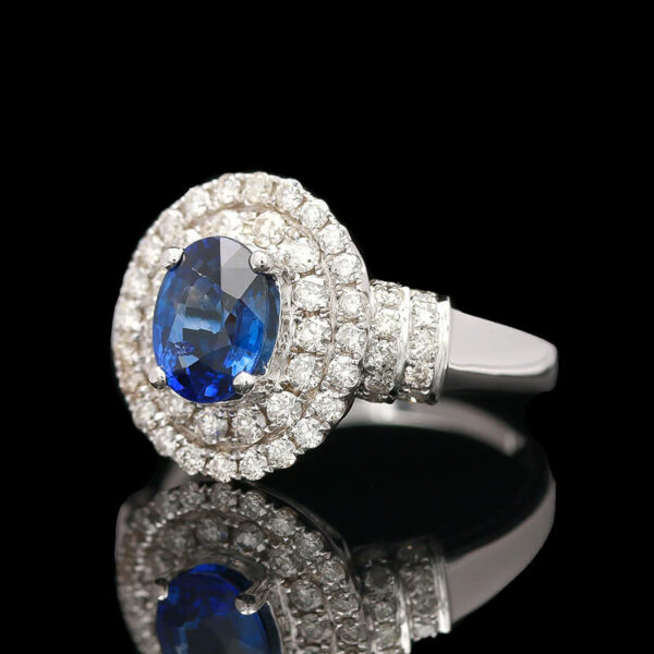 a blue and white diamond ring on a black surface